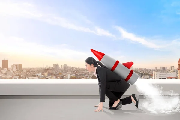 Excited asian business woman on the rooftop with rocket ready to — Stock Photo, Image
