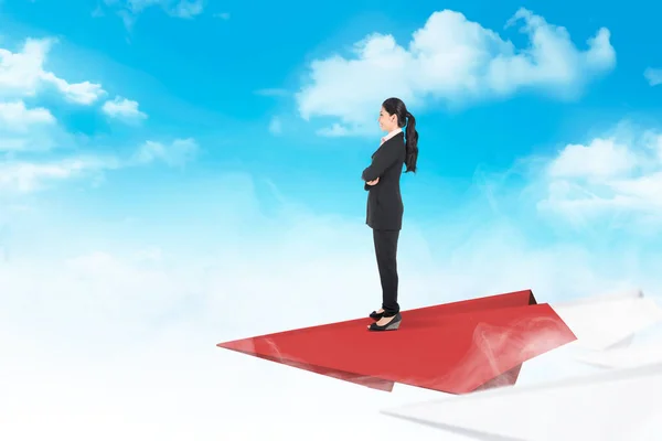 Красива азіатська бізнес-леді, що стоїть на паперовому літаку летить — стокове фото