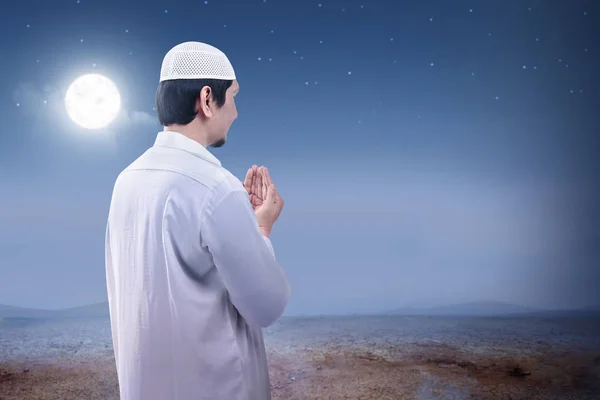 Widok z tyłu Azjatycka muzułmańskich człowieka podniósł ręce i modląc się na sa — Zdjęcie stockowe