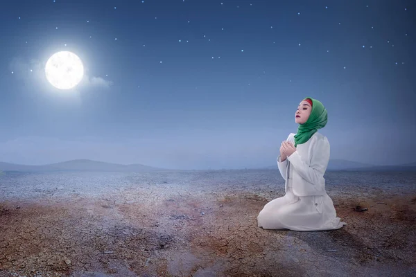 Junge asiatische muslimische Frau sitzt im Gebet Position, während angehoben h — Stockfoto
