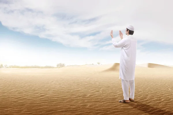 Rear view of asian muslim man raised hands and praying on the sa — Stock Photo, Image