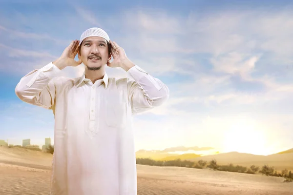 Souriant asiatique musulman homme avec chapeau debout et prier sur la sa — Photo
