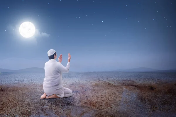 亚洲穆斯林男子坐在祈祷的位置, 而 rai 的后视图 — 图库照片