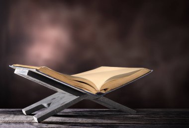 Kur'an-ı Kerim bulanık arka plan üzerinde ahşap masa üzerinde ahşap Amerikan Servisi içinde açmak