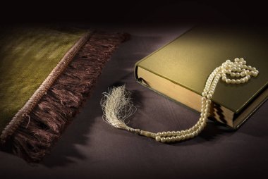 Yere mat siyah arka plan üzerinde Kur'an ve tespih dua ile