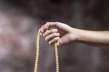 Müslüman dua boncuklarını ile bulanık arka plan üzerinde dua eller