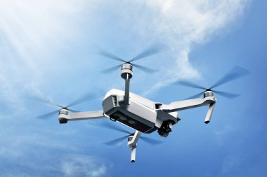 Beyaz dron mavi gökyüzü arka plan üzerinde havada uçan kamera ile