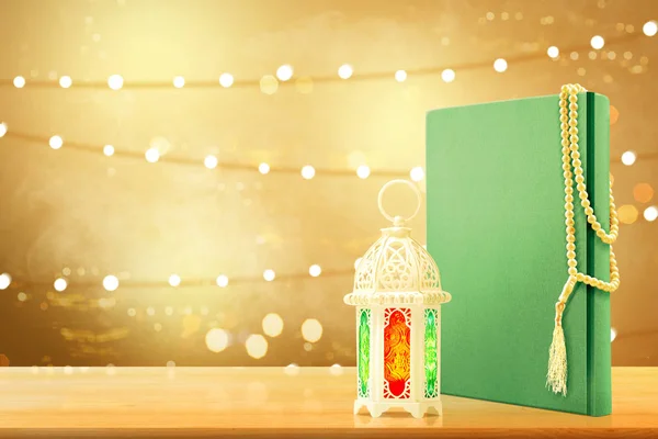 Corano con perline di preghiera e lampada araba con bella luce accesa — Foto Stock