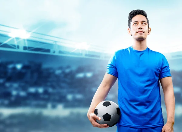 Joueur de football asiatique homme en maillot bleu tenant le ballon sur le — Photo