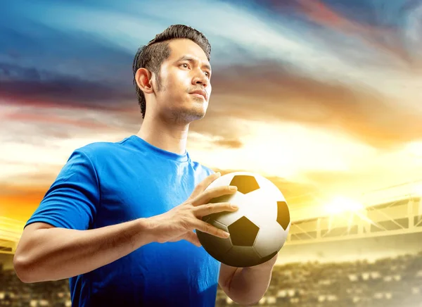 Joueur de football asiatique homme en maillot bleu tenant le ballon sur le — Photo