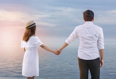 Asyalı romantik çift in arka görünümü üzerinde el ele tutuşuyor