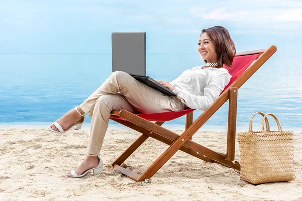 Asiática mulher de negócios trabalhando com laptop sentado na praia ch — Fotografia de Stock