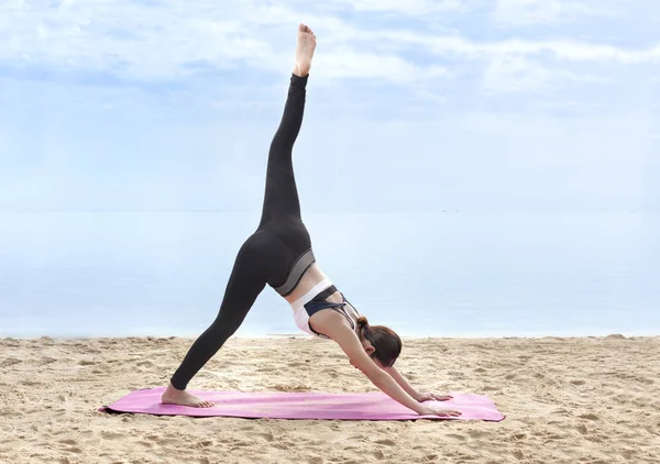 Asian healthy woman practicing yoga on the carpet in beach — Stock Photo, Image