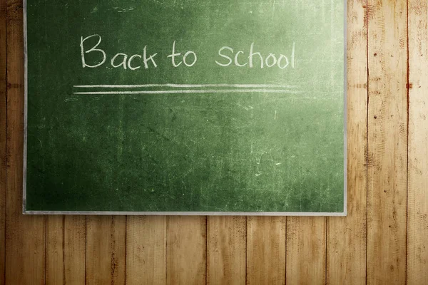 Tableau noir avec message de rentrée scolaire sur un mur en bois — Photo