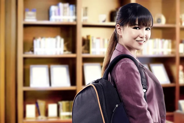 Asiatico studente donna con zaino in piedi e guardare indietro nel — Foto Stock