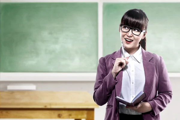 Азіатський студент жінка з ноутбуком і ручкою щось думає в — стокове фото