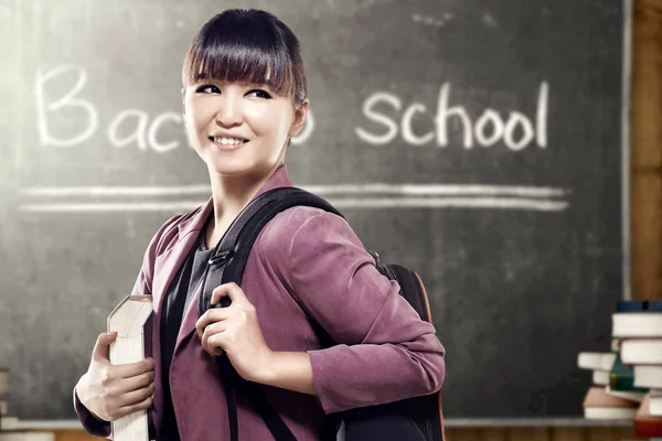 Asiático estudante mulher com mochila carregando livro de pé e loo — Fotografia de Stock
