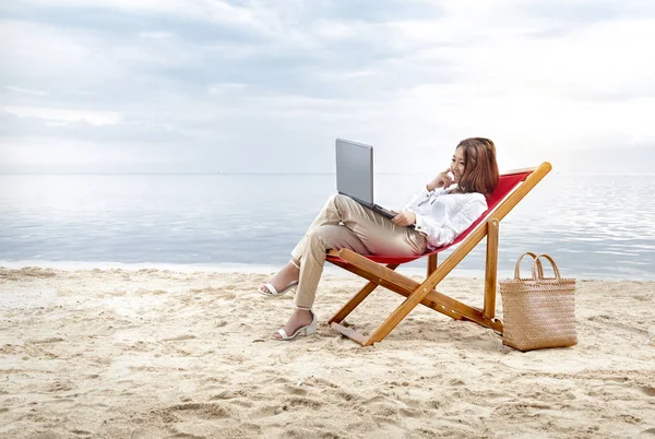 Asiatico business donna working con laptop seduta in il spiaggia ch — Foto Stock