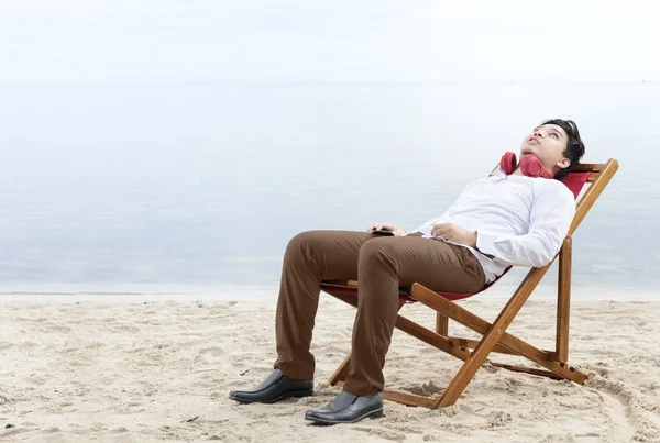 Asiático hombre de negocios relajarse celebración de teléfono móvil mientras se utiliza headpho —  Fotos de Stock