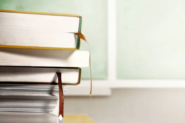 Nahaufnahme eines Bücherstapels auf Holztisch mit Kreidetafel — Stockfoto