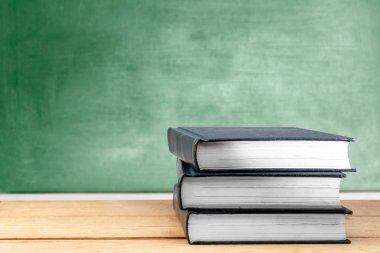 Tahta arka plan lı ahşap masa üzerine kitap yığını