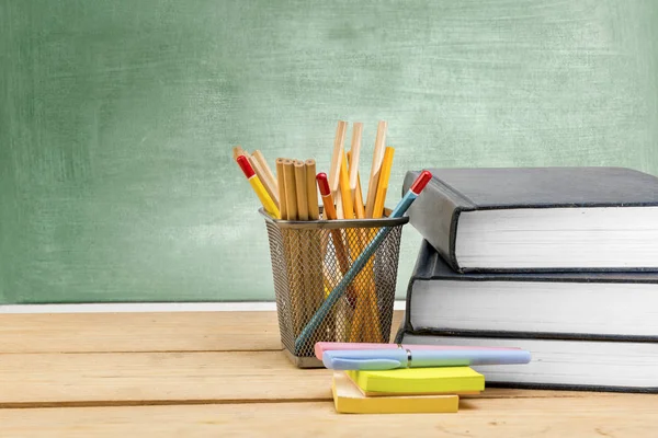 Stapel boeken met noten papier en pen met potloden in basket co — Stockfoto