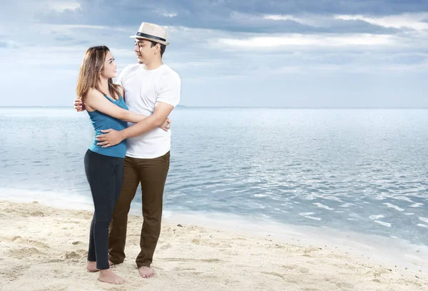 Feliz asiático hombre en sombrero abrazando su novia en la playa —  Fotos de Stock