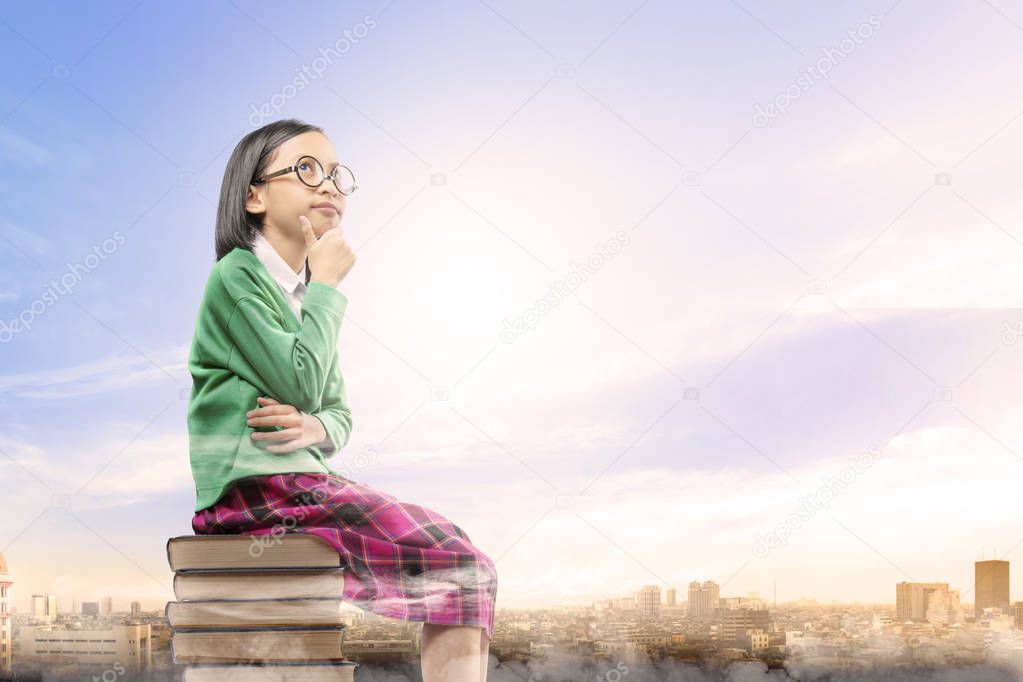 Asian cute girl with glasses think while sitting on the pile of 