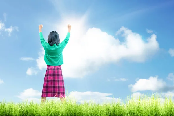 Rear view of asian cute girl standing while raised arms on the g — Stock Photo, Image