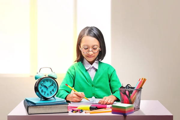 Asiatisk søt jente med briller som lærer seg å stå i ro på skolen – stockfoto