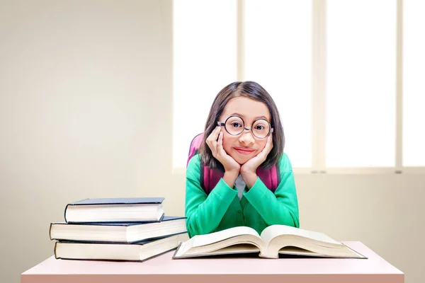 Ázsiai aranyos lány szemüveg és hátizsák könyvek az íróasztalon — Stock Fotó