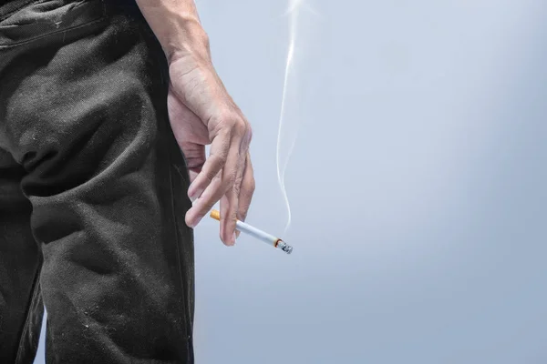 Man staat met een sigaret op zijn hand — Stockfoto