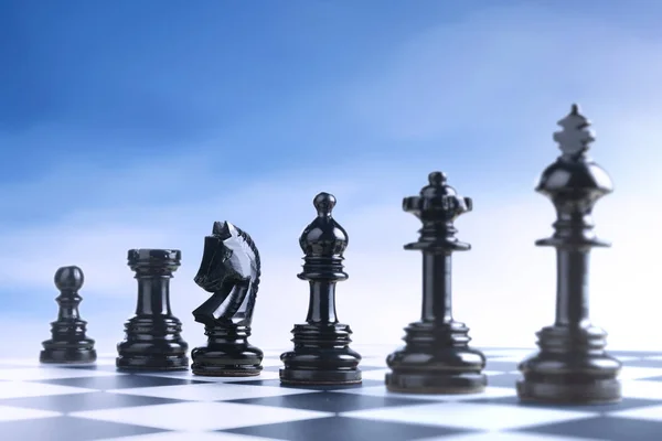 Række af sort skak stykke - Stock-foto