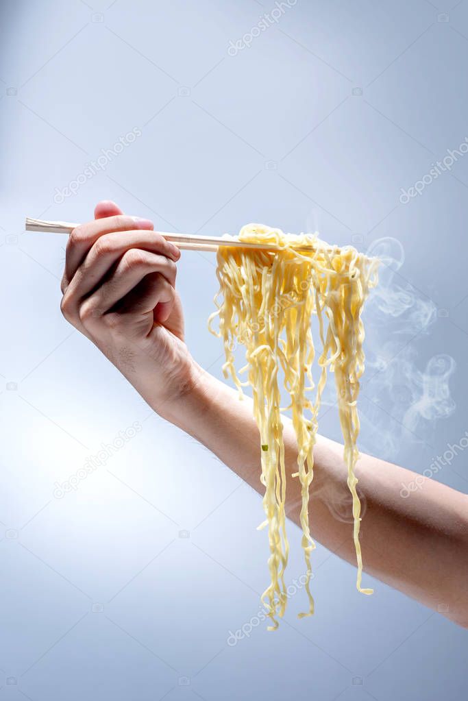 People eat the noodles with chopsticks