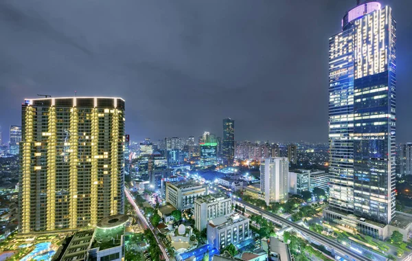 Ciudad de Yakarta skyline con rascacielos urbanos por la noche —  Fotos de Stock