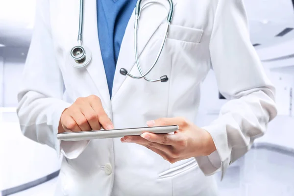 Femme médecin en blouse blanche et stéthoscope en utilisant une tablette — Photo