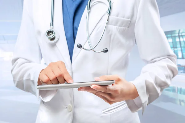 Femme médecin en blouse blanche et stéthoscope en utilisant une tablette — Photo
