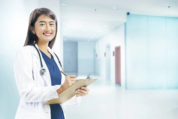 Asiatique femme médecin en blanc blouse et stéthoscope holding cli — Photo