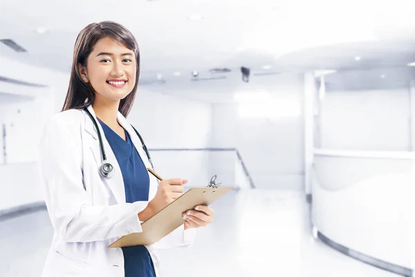 Asiatique femme médecin en blanc blouse et stéthoscope holding cli — Photo