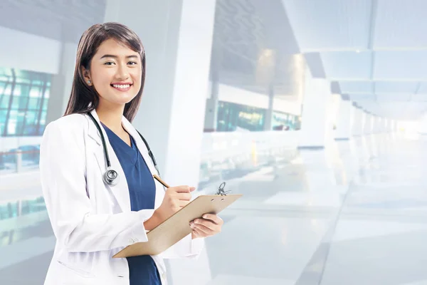 Asiático mulher médico em branco jaleco e estetoscópio segurando cli — Fotografia de Stock