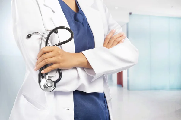 Mulher médico em jaleco branco segurando estetoscópio em suas mãos — Fotografia de Stock