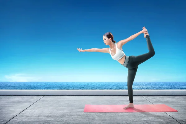 Aziatische gezonde vrouw beoefenen van yoga op het tapijt op het terras — Stockfoto