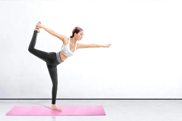 Asiatische gesunde Frau praktiziert Yoga auf dem Teppich in Innenräumen — Stockfoto