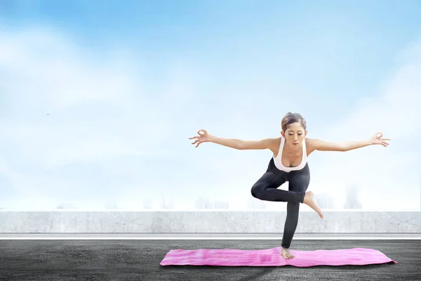 Asian healthy woman practicing yoga on the carpet at rooftop — Stock Photo, Image