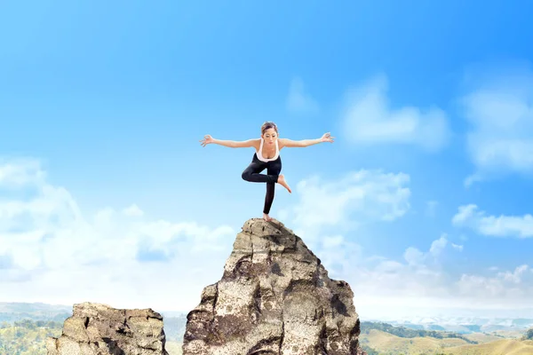 Asiatische gesunde Frau praktiziert Yoga auf dem Felsen — Stockfoto