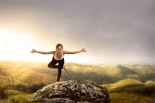 Asiatisk frisk kvinna som tränar yoga på klippan — Stockfoto