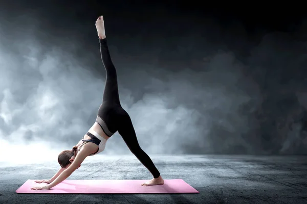 Asiatische gesunde Frau praktiziert Yoga auf dem Teppich in Innenräumen — Stockfoto
