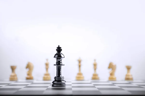 Pieza de ajedrez rey negro de pie delante de todo el grupo de woode — Foto de Stock