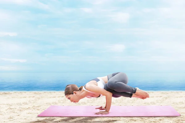 Asiatica donna sana che pratica yoga sul tappeto sulla spiaggia di sabbia — Foto Stock