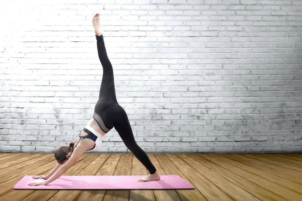 Asiatische gesunde Frau praktiziert Yoga auf dem Teppich in Innenräumen — Stockfoto